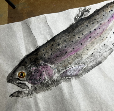 A watercolor painting of a fish on paper, showing a long, slender body with pink and purple accents and black spots.