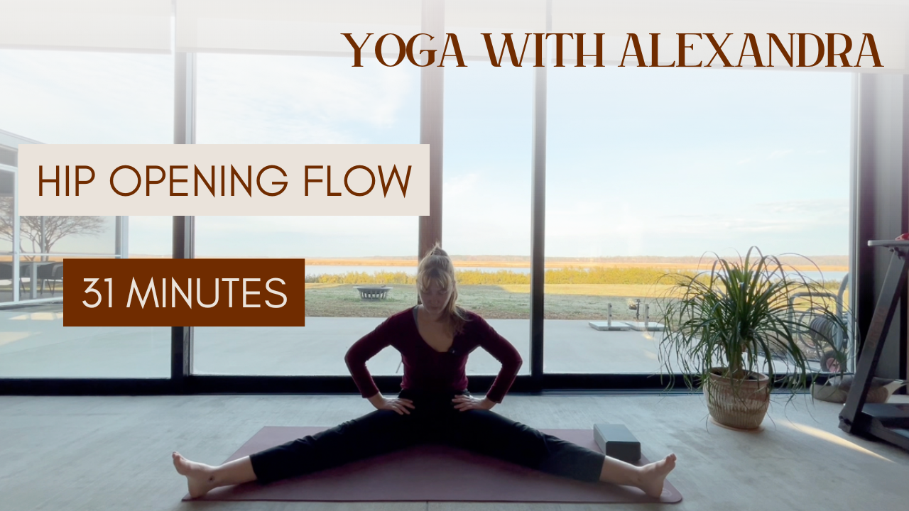 Woman practicing yoga in a room with large windows, performing a wide-legged seated stretch. Text overlays include 'Yoga with Alexandra,' 'Hip Opening Flow,' and '31 Minutes'.