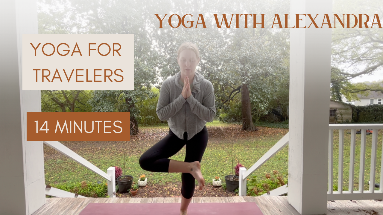 A woman practicing yoga outdoors on a porch, balancing on one leg with hands in prayer position, trees and greenery in the background, promoting a 14-minute yoga session for travelers with Alexandra.