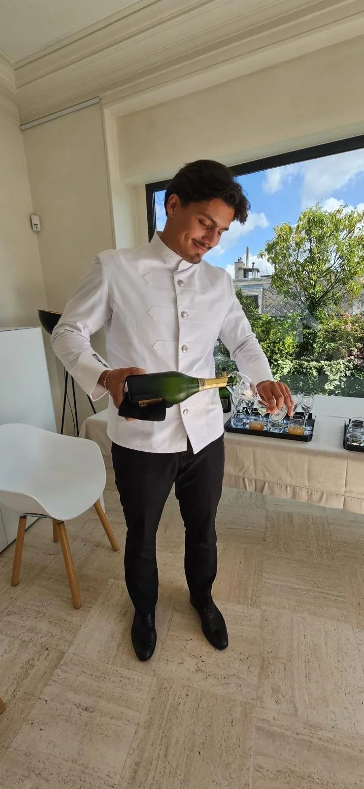 Service de prestige pour réception privée : serveur versant du champagne lors d'un cocktail familial géré par Philippe Hereng.