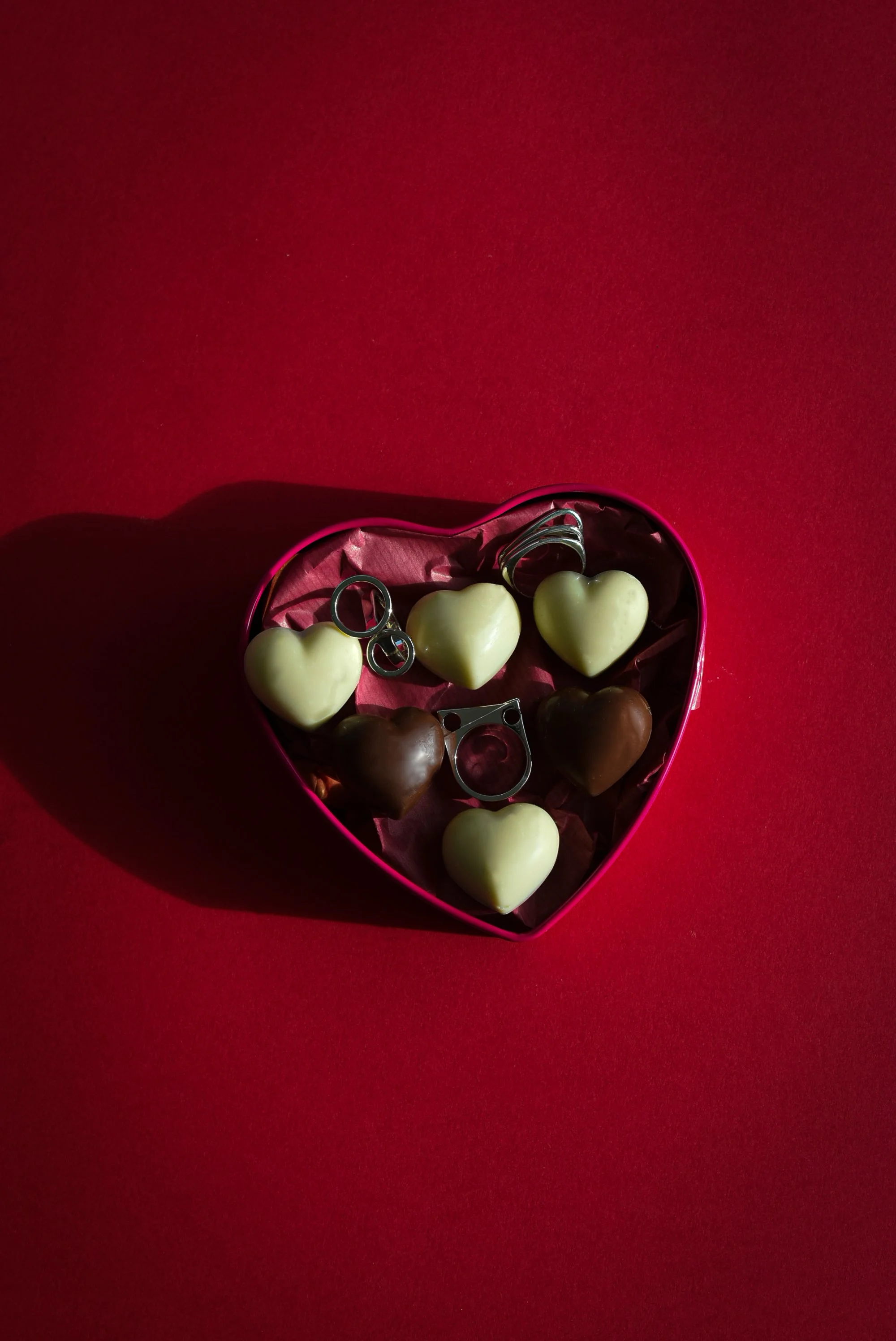 Photographie de bijoux et création de contenu réseaux sociaux : bagues Mustraus présentées dans un coffret de chocolats de luxe, concept marketing visuel pour joaillerie.