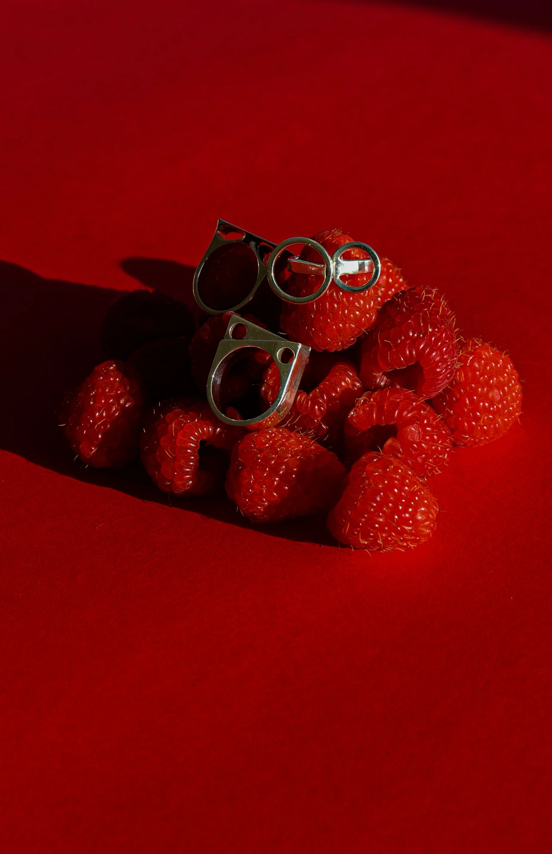 Création de contenu visuel pour joaillerie : mise en scène de bagues Mustraus sur des framboises, campagne réseaux sociaux pour la Saint-Valentin.
