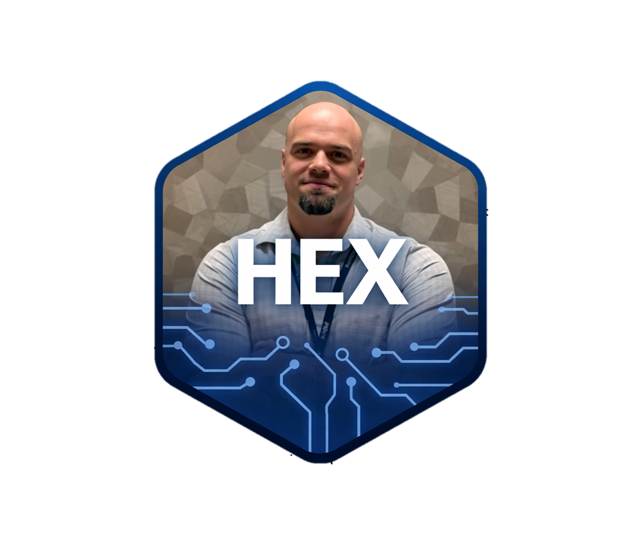 A man with a bald head and goatee, wearing a gray shirt, standing against a neutral background. The image features a hexagon graphic with the word "HEX" in white letters and some digital circuit design elements at the bottom.