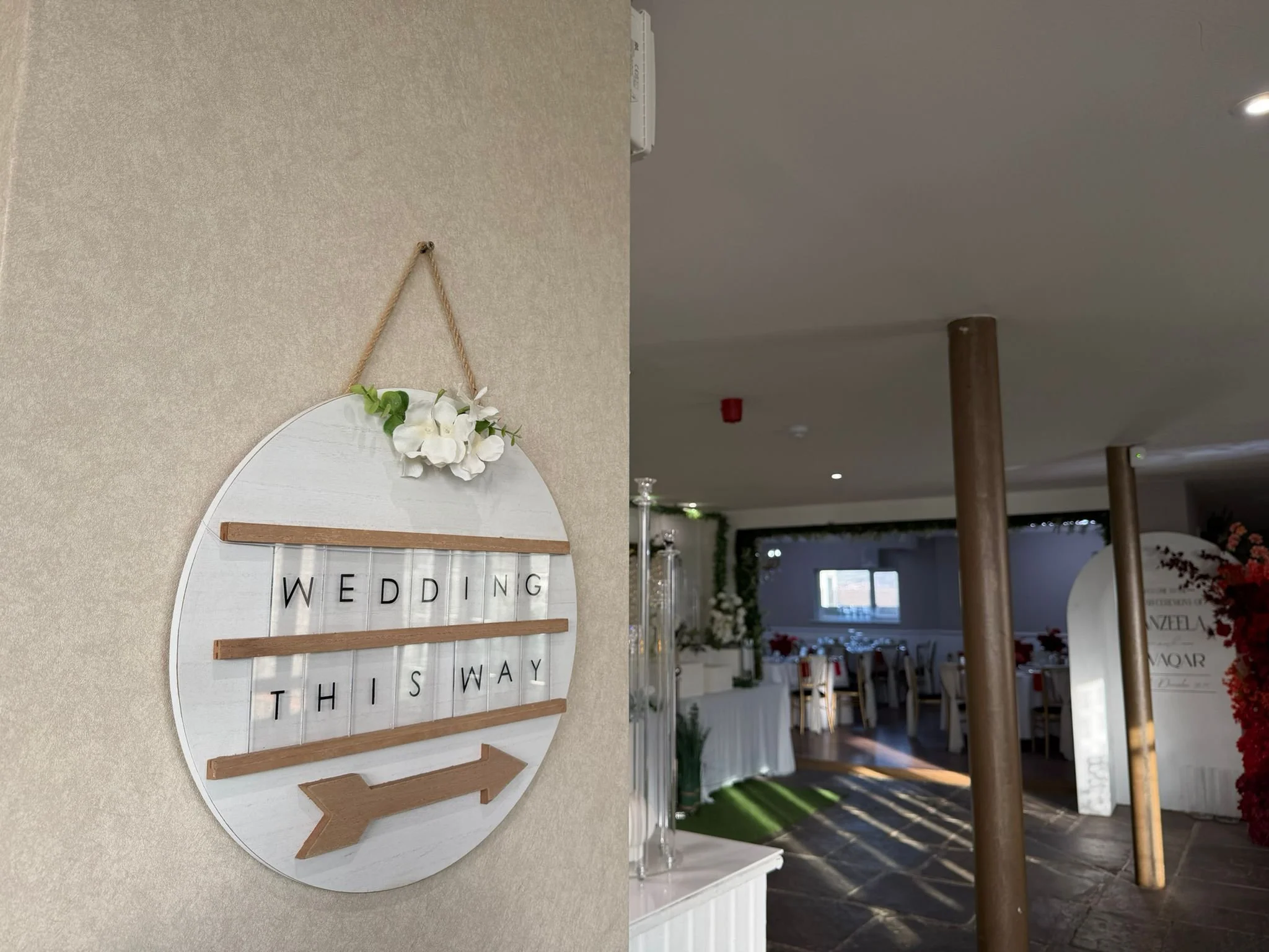 Wedding sign with arrow inside a venue.
