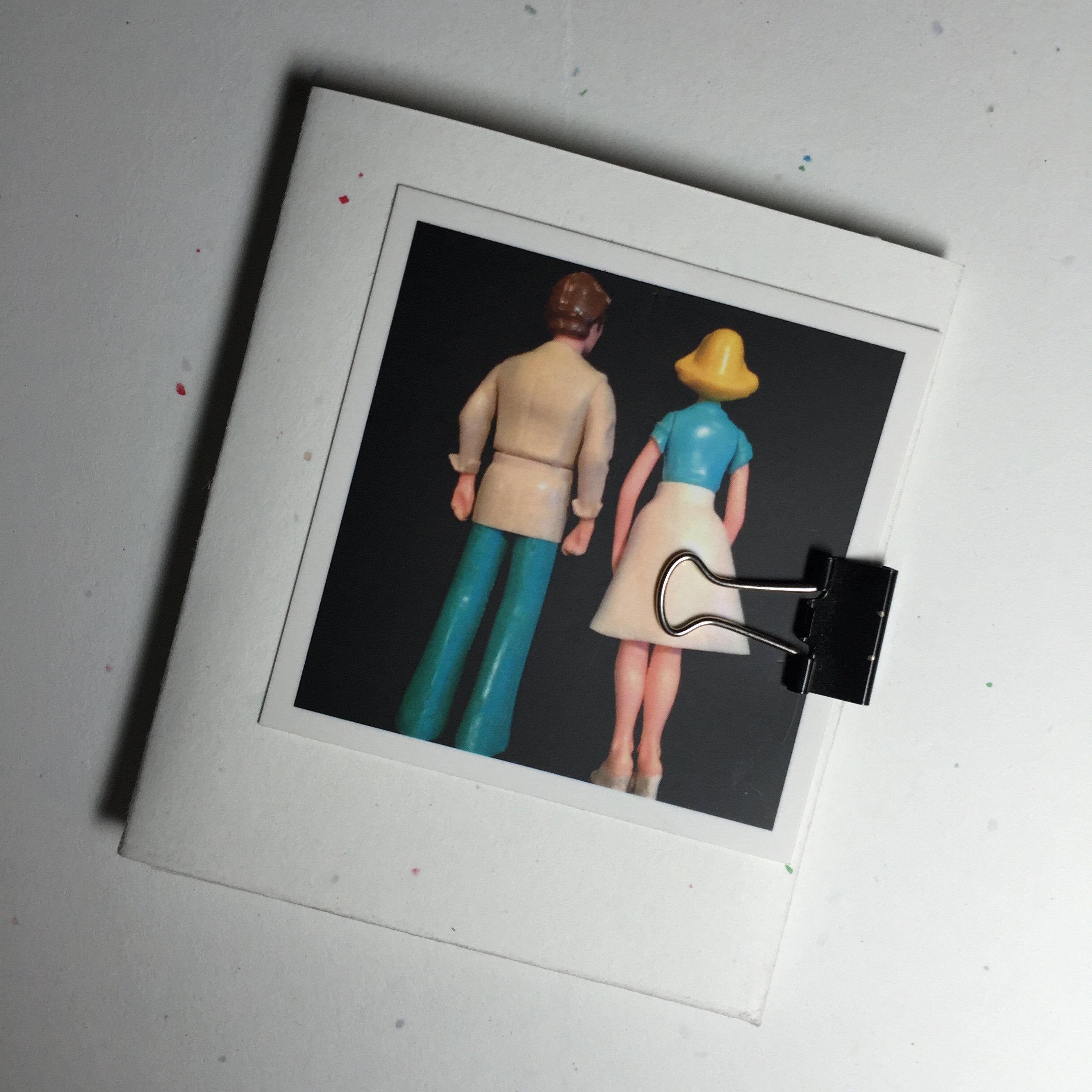 original artwork cover titled 'my dollhouse (how did I get here)' by Debbi Spranza. Two dollhouse figures with their backs to the camera