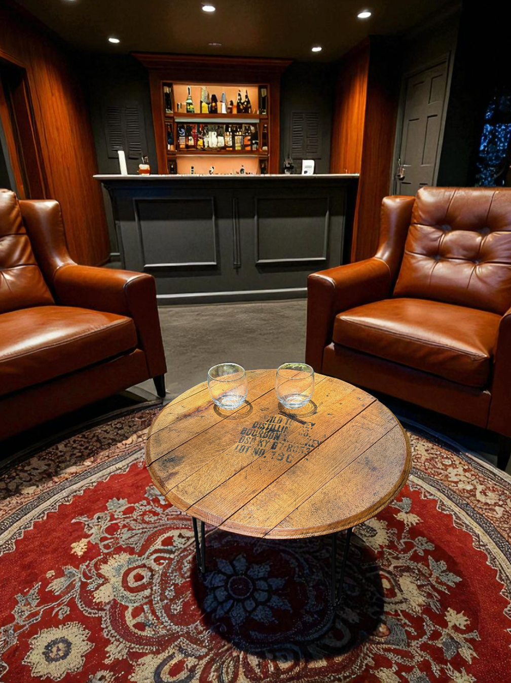 A cozy bar area with two brown leather armchairs facing each other, a round wooden coffee table with two glasses on it, a red patterned rug underneath, and a black bar counter with shelves of bottles behind it, all illuminated by ceiling lights.