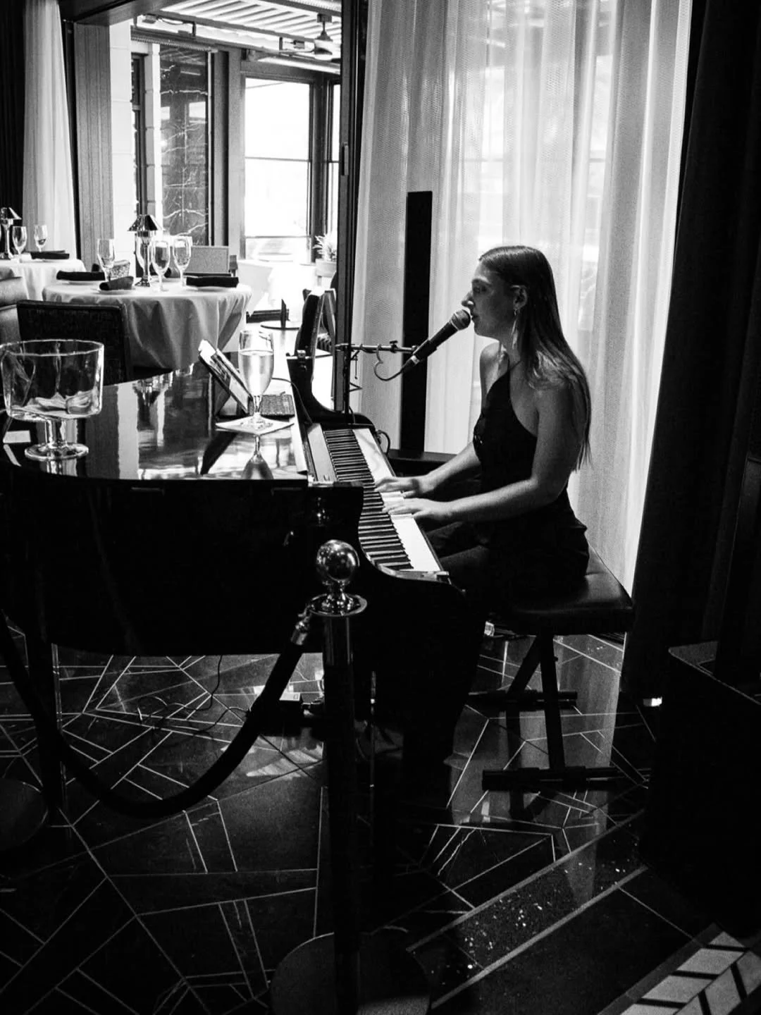 Photo of Jordan Hope Popovsky performing live on piano and vocals in an intimate venue setting.