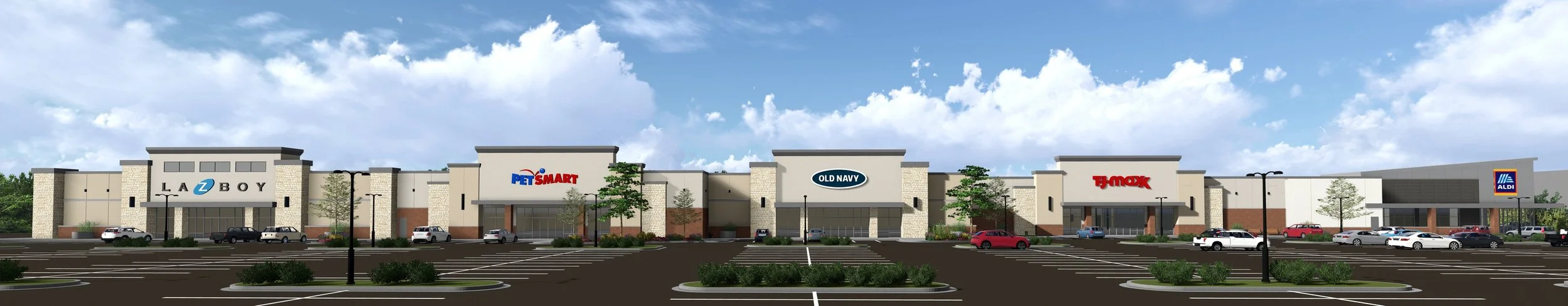 Renaissance at Colony Park, Ridgeland, MS. A shopping mall parking lot with cars and signage for stores including Lazboy, PetSmart, Old Navy, T.J.Maxx, and Aldi, and a partly cloudy sky above.