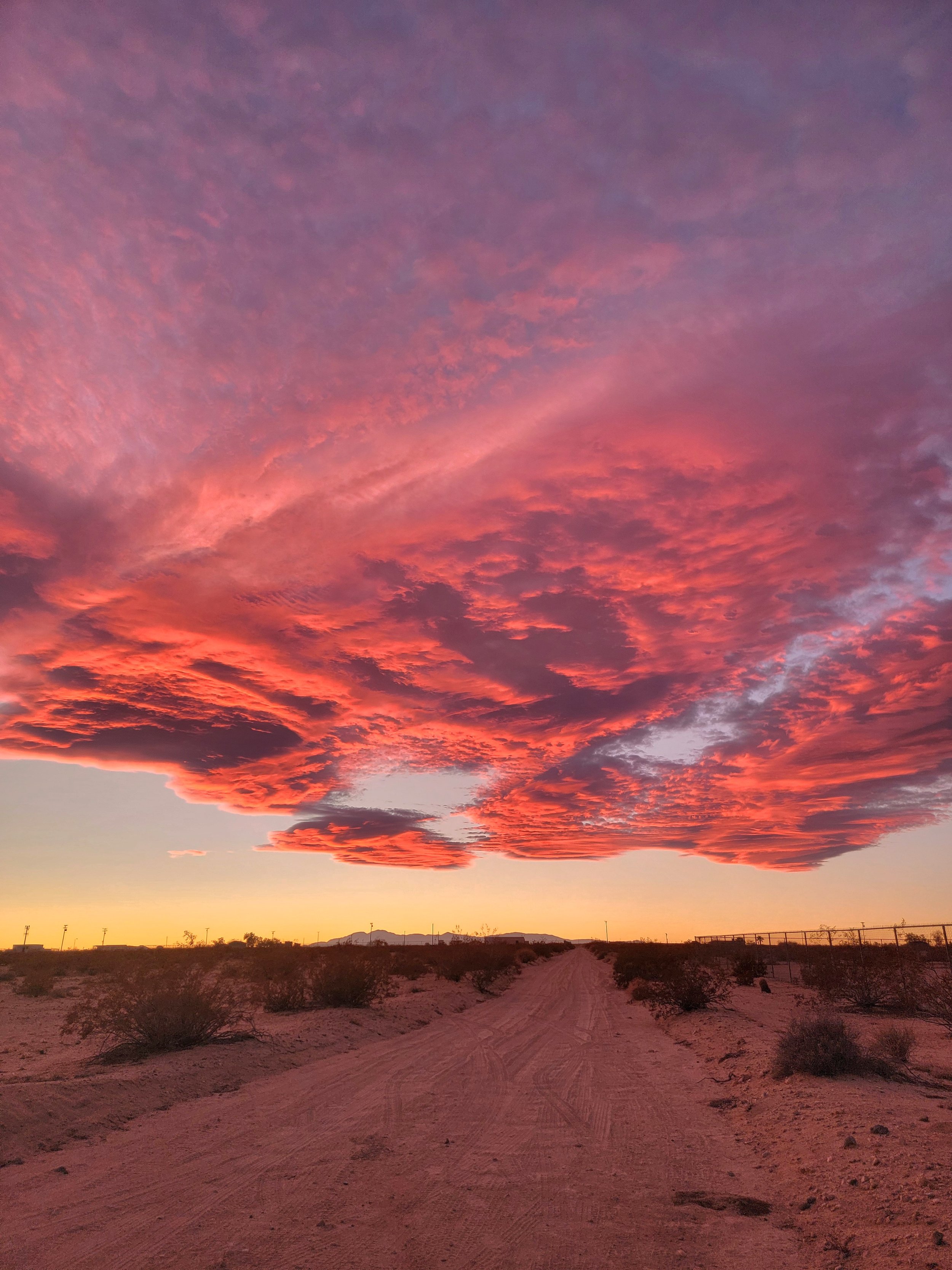 Magenta sunset skies over a high desert dirt road near Joshua Tree and Twentynine Palms, California