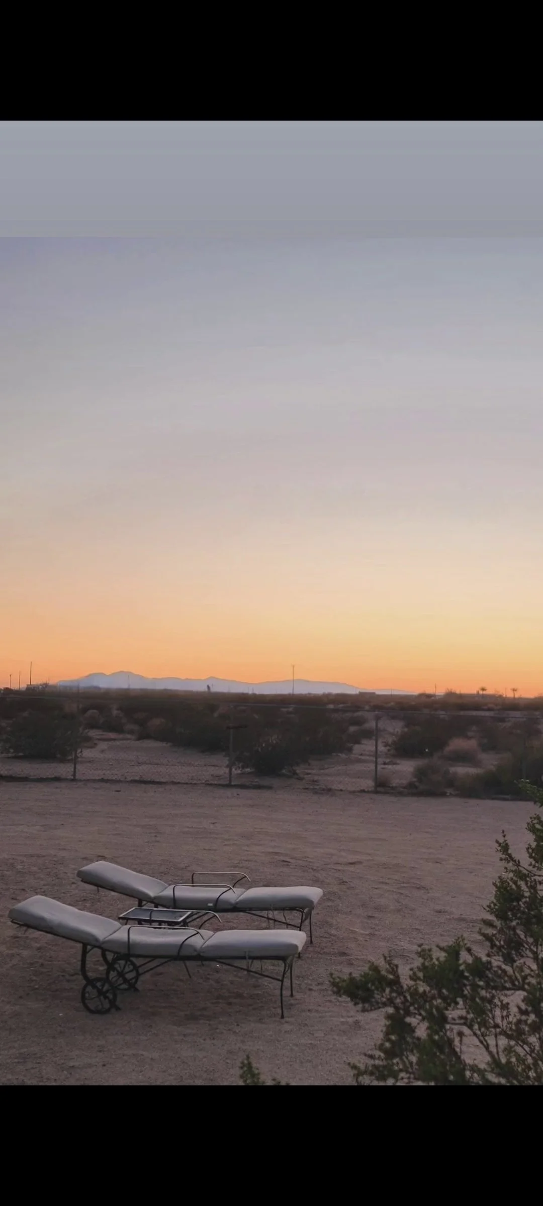 Outdoor lounge chairs at Kit Fox Cabin overlooking the high desert near Joshua Tree at sunset