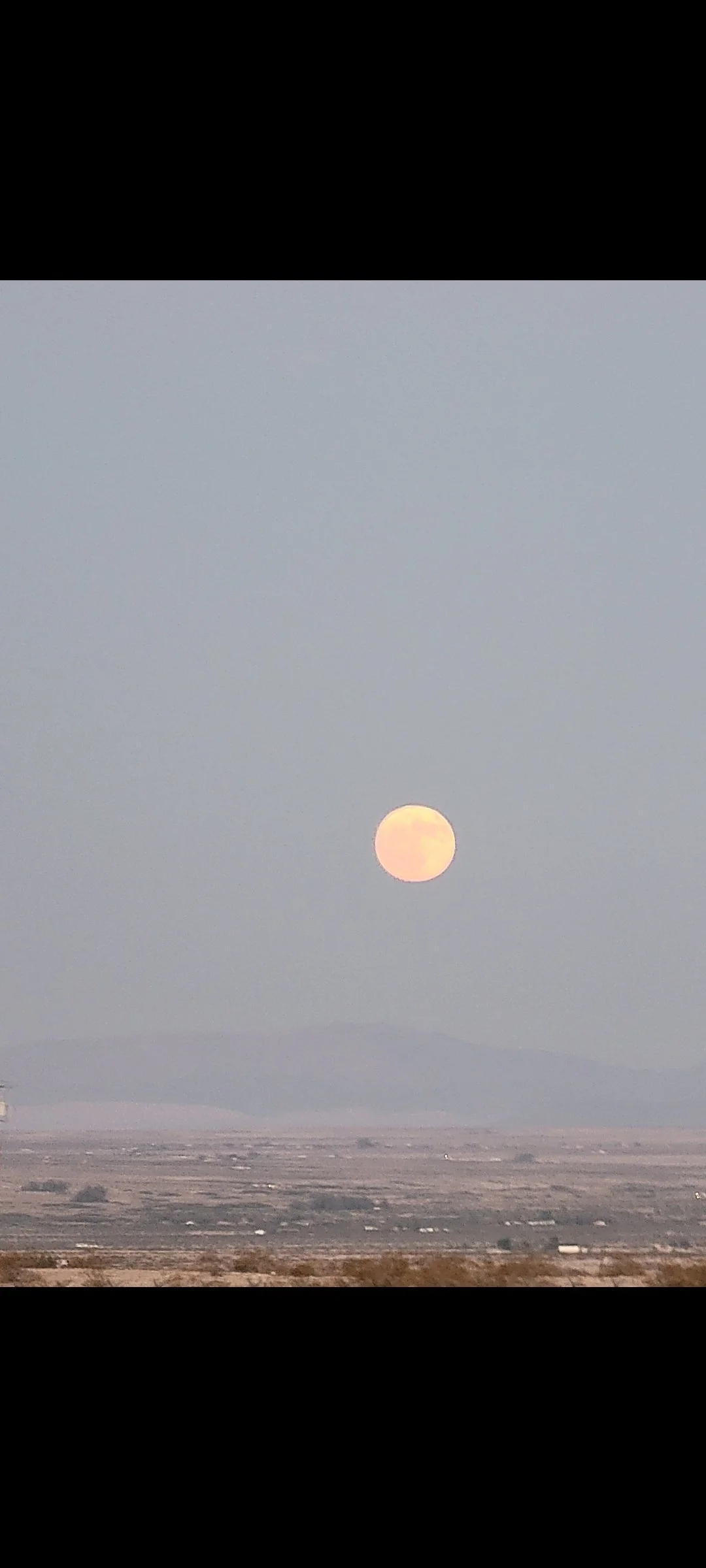 Full moon rising over the high desert landscape near Joshua Tree and Twentynine Palms, California