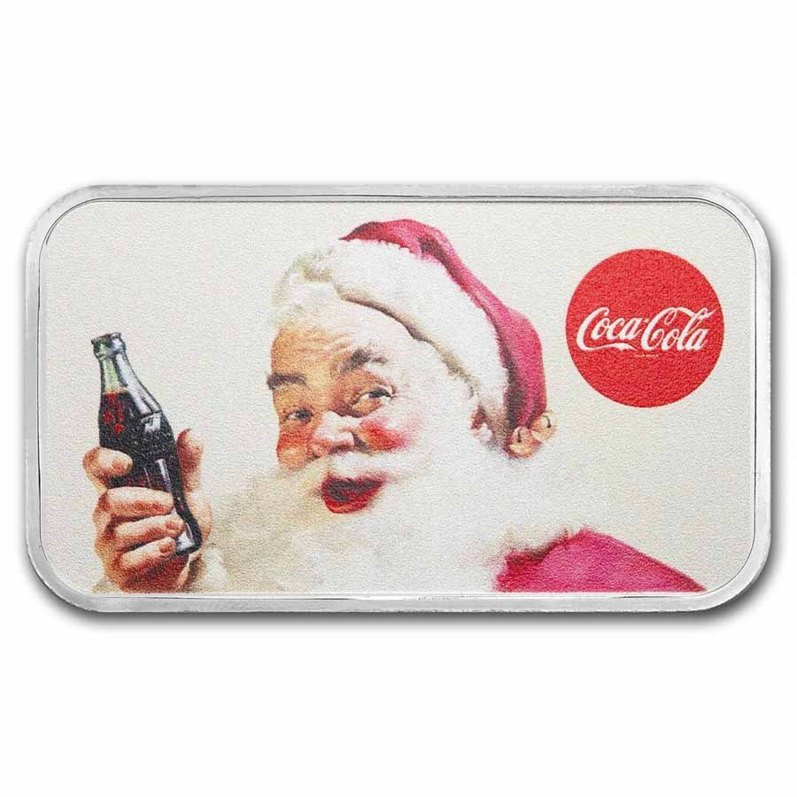 A tin with a holiday-themed image of Santa Claus holding a Coca-Cola bottle, smiling, wearing a red Santa hat, with a red Coca-Cola logo in the top right corner.