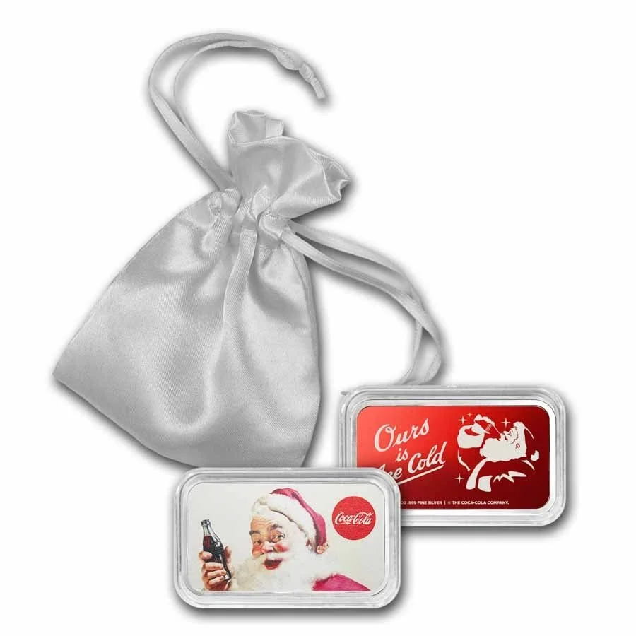Two vintage Coca-Cola containers, one with Santa Claus and one with a Santa quote, along with a white satin drawstring bag.