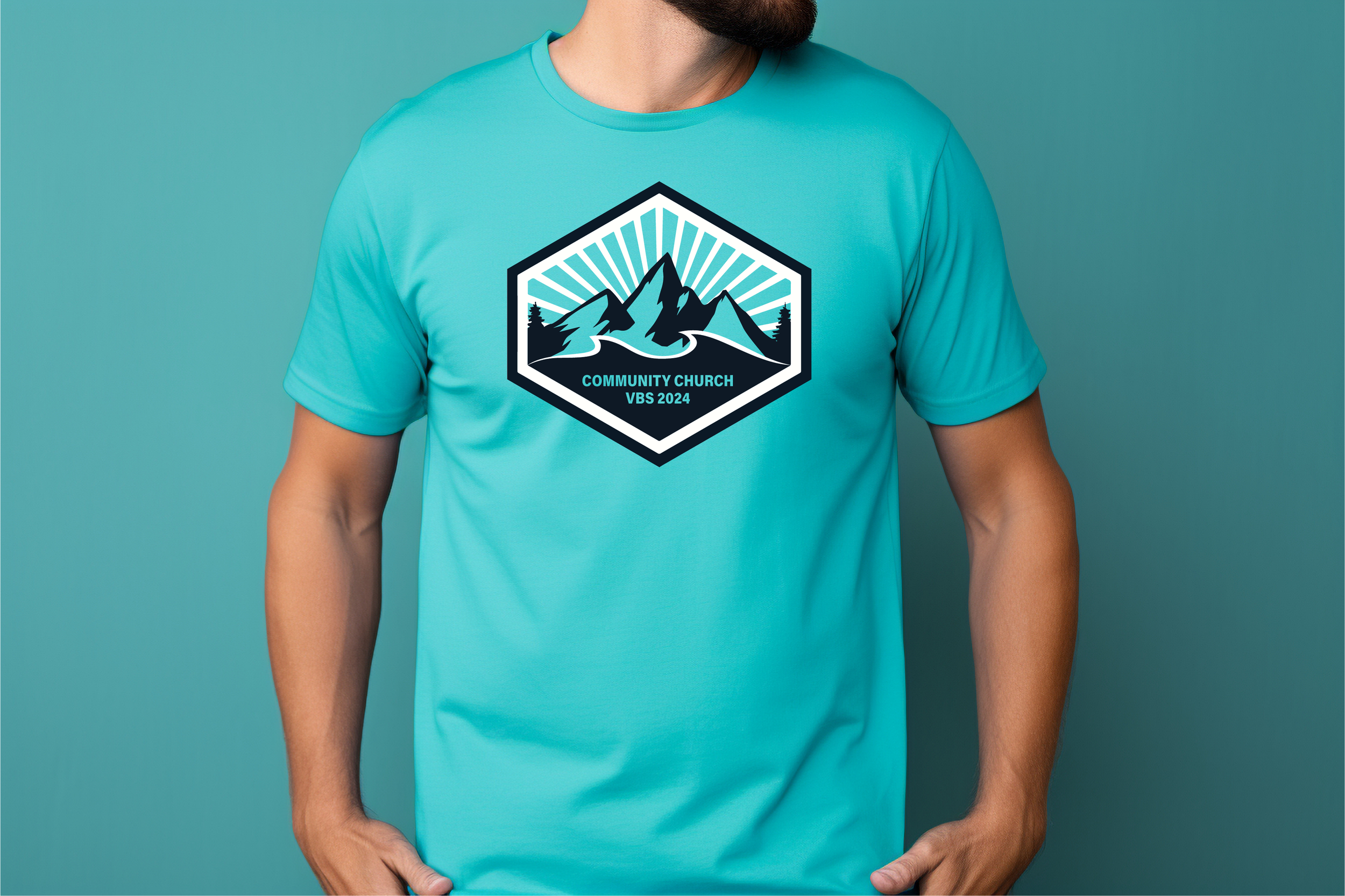 A person wearing a turquoise T-shirt with a mountain and forest logo and the text 'Community Church VBS 2024'.