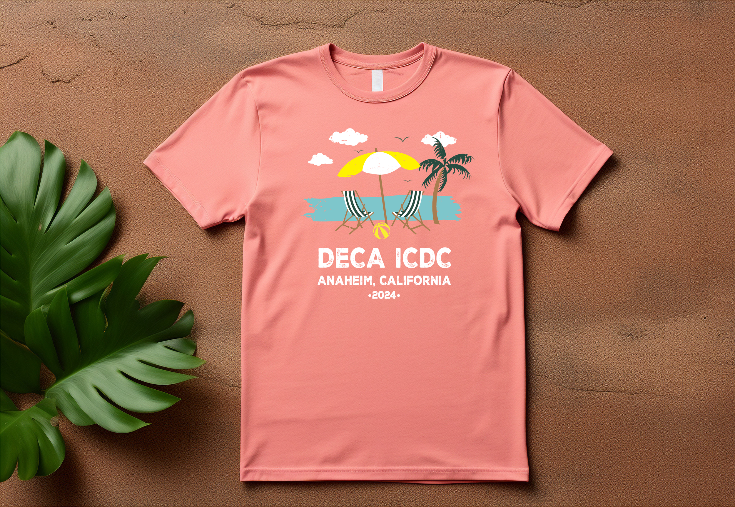 Pink T-shirt with graphic of a beach scene featuring a yellow and white umbrella, two striped chairs, a palm tree, clouds, and birds, with text "DECA ICDC, Anaheim, California, 2024".