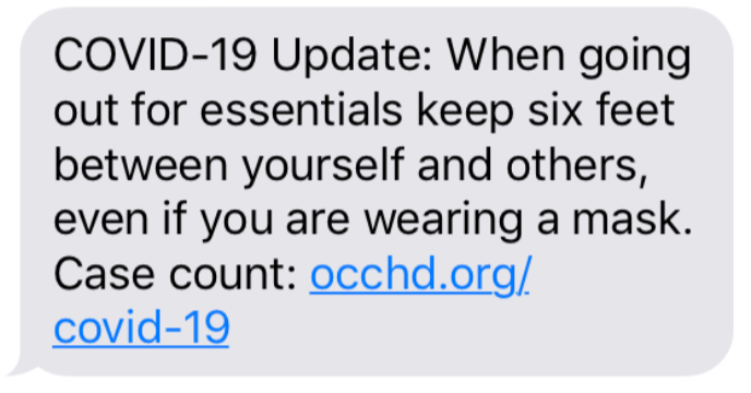 A text message providing a COVID-19 update about maintaining six feet of distance, even if wearing masks, with a link to occhd.org/covid-19.