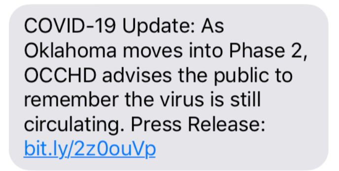 Screenshot of a text message about a COVID-19 update for Oklahoma entering Phase 2, reminding the public that the virus is still circulating, with a link to more information.