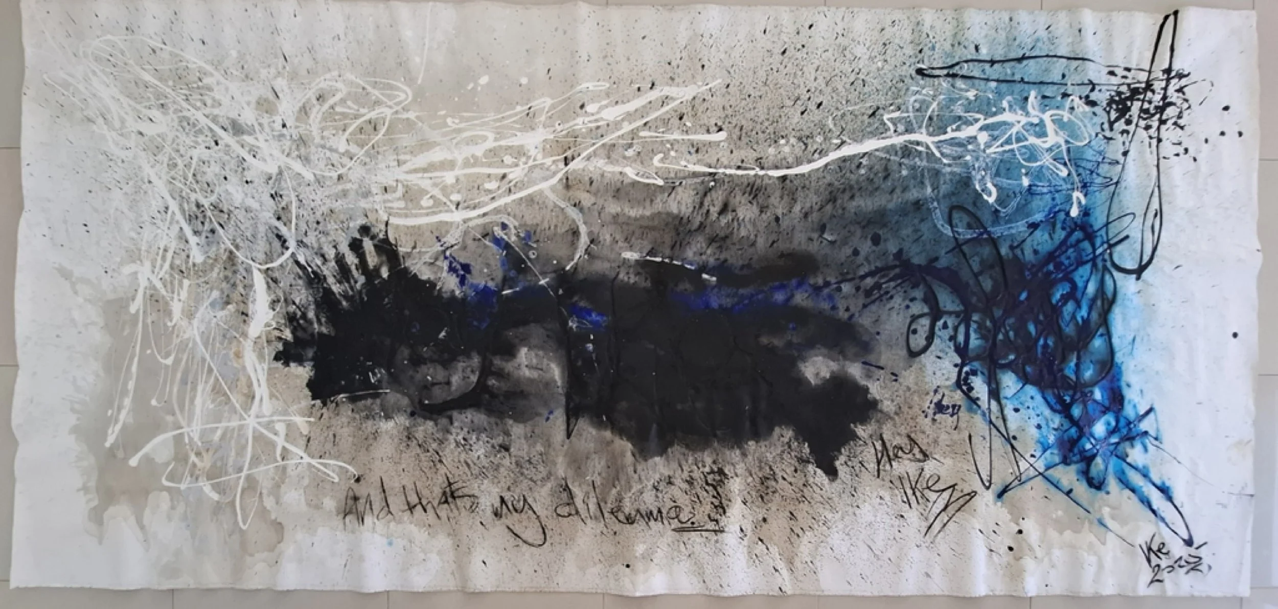Abstract mixed media artwork with chaotic white, black, and blue splatters, lines, and scribbles on a textured background. Handwritten text on the bottom reads "And that my dilemma may like" and the signature "Kie 2021".
