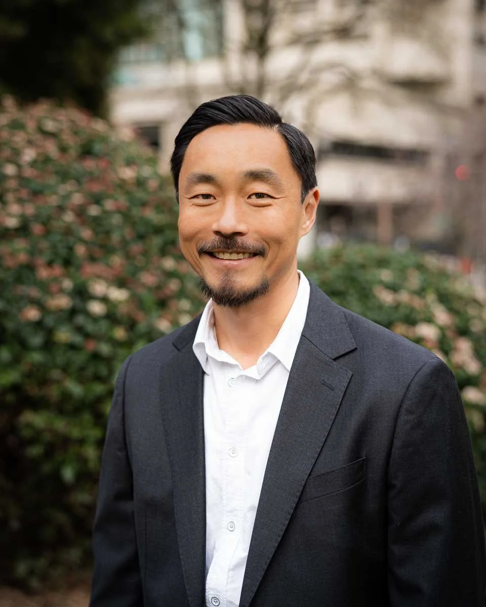 Outdoor headshot of a man in a park in downtown Portland.