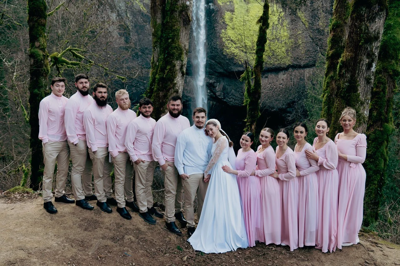 Bridal party in a forest with a waterfall behind them