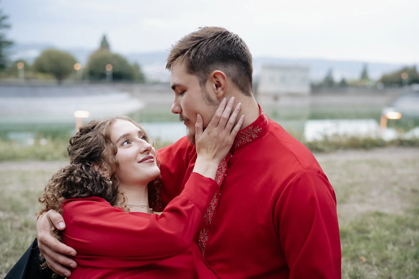 Couple in matching red laying on the forest floor together