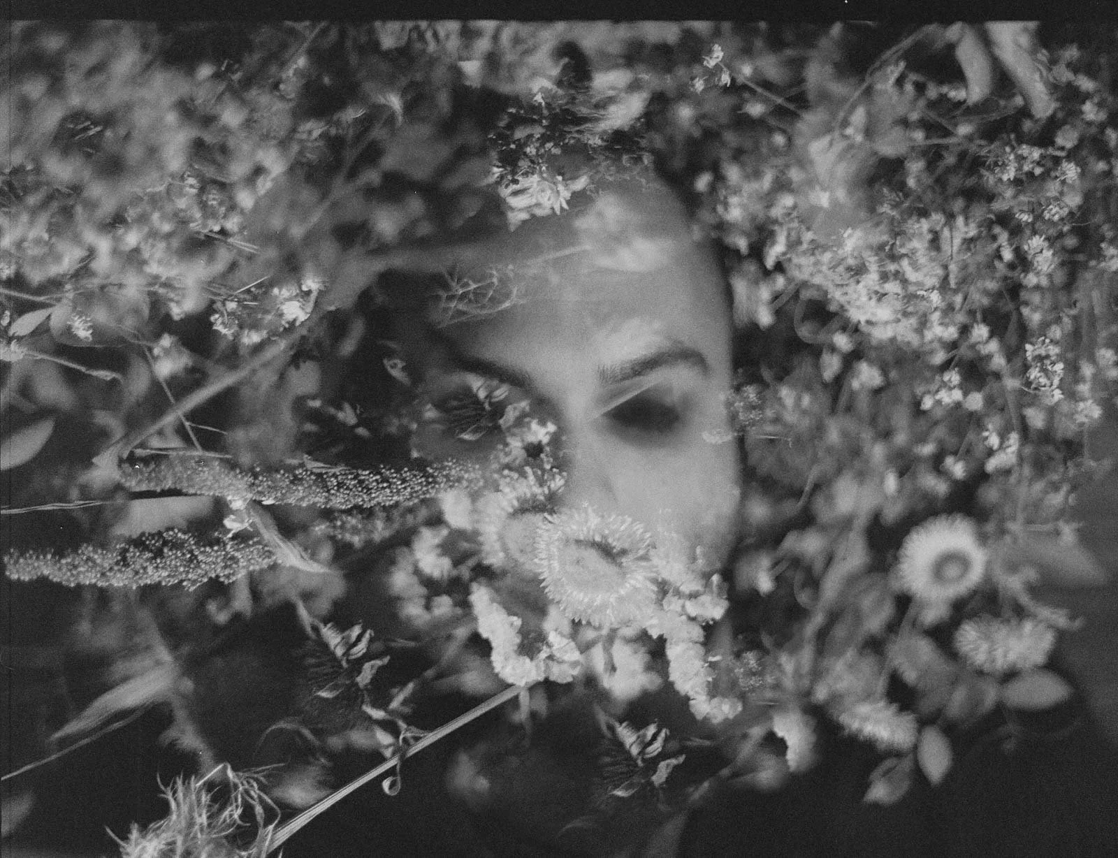 A double exposure of musician Feverkin, with plants seeming to grow out of his face