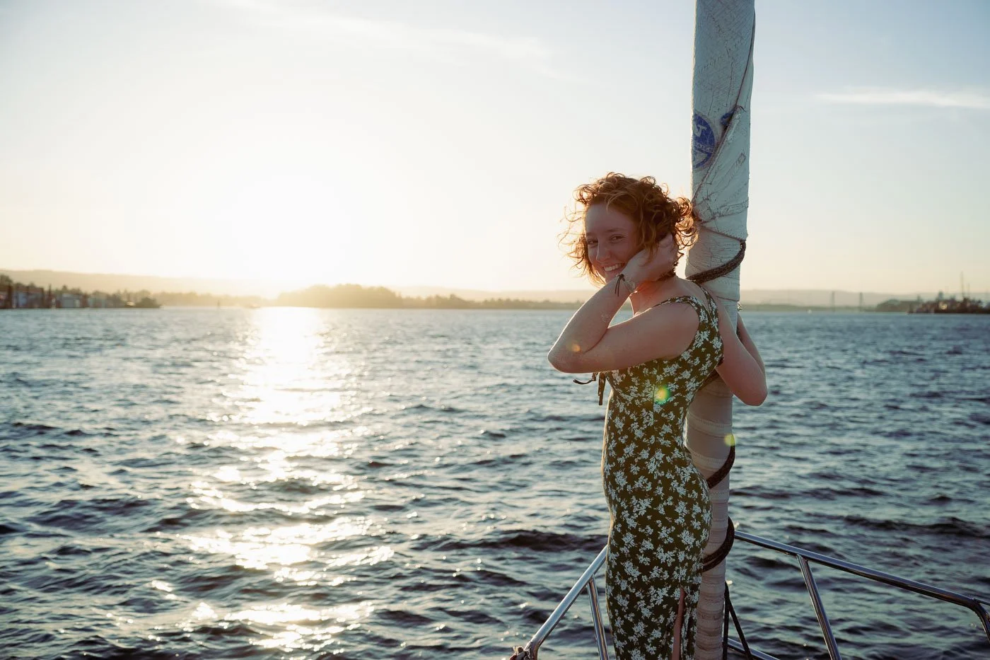 A girl standing at the bow of a sail boat