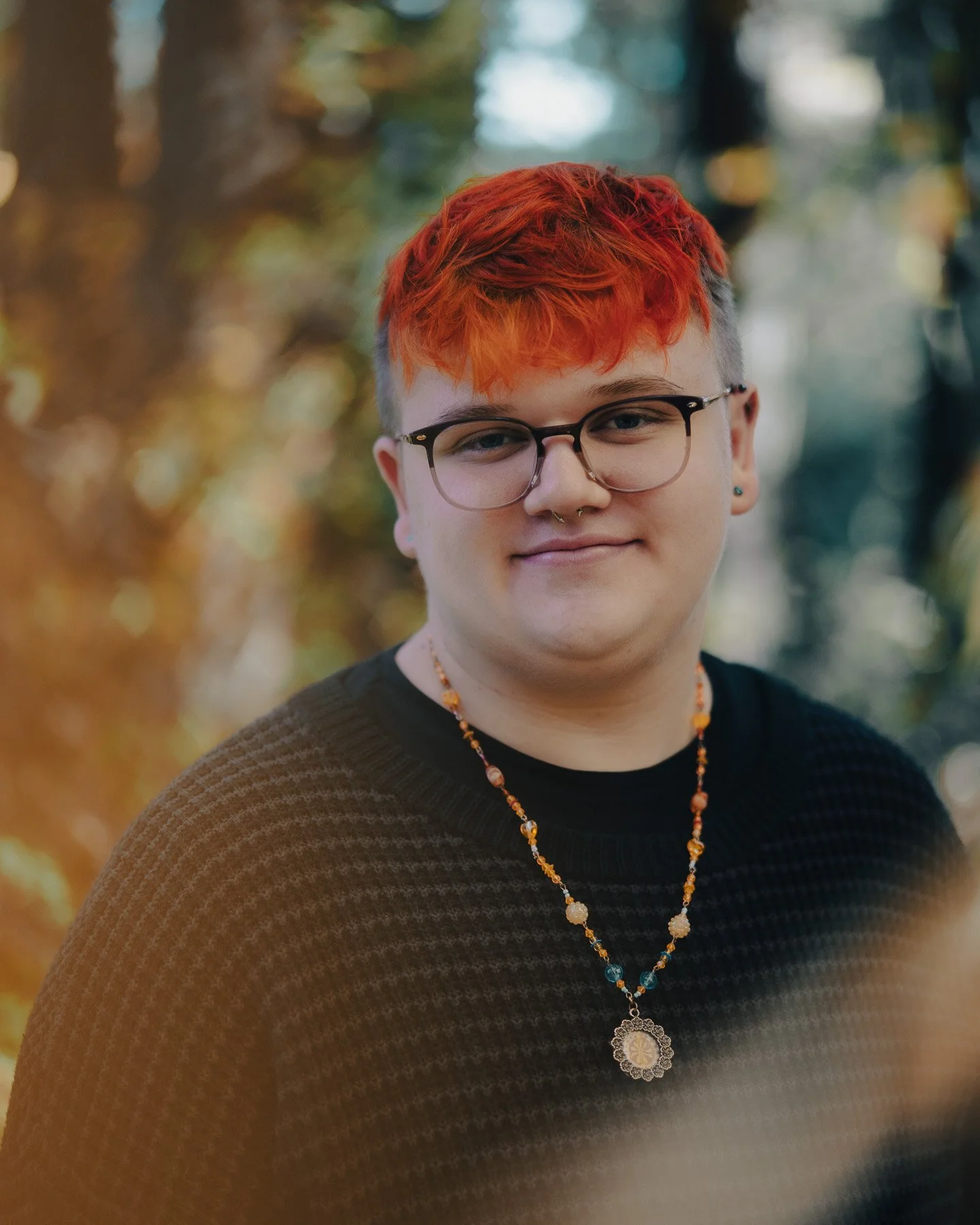 A high school graduate with red hair posing in the forest
