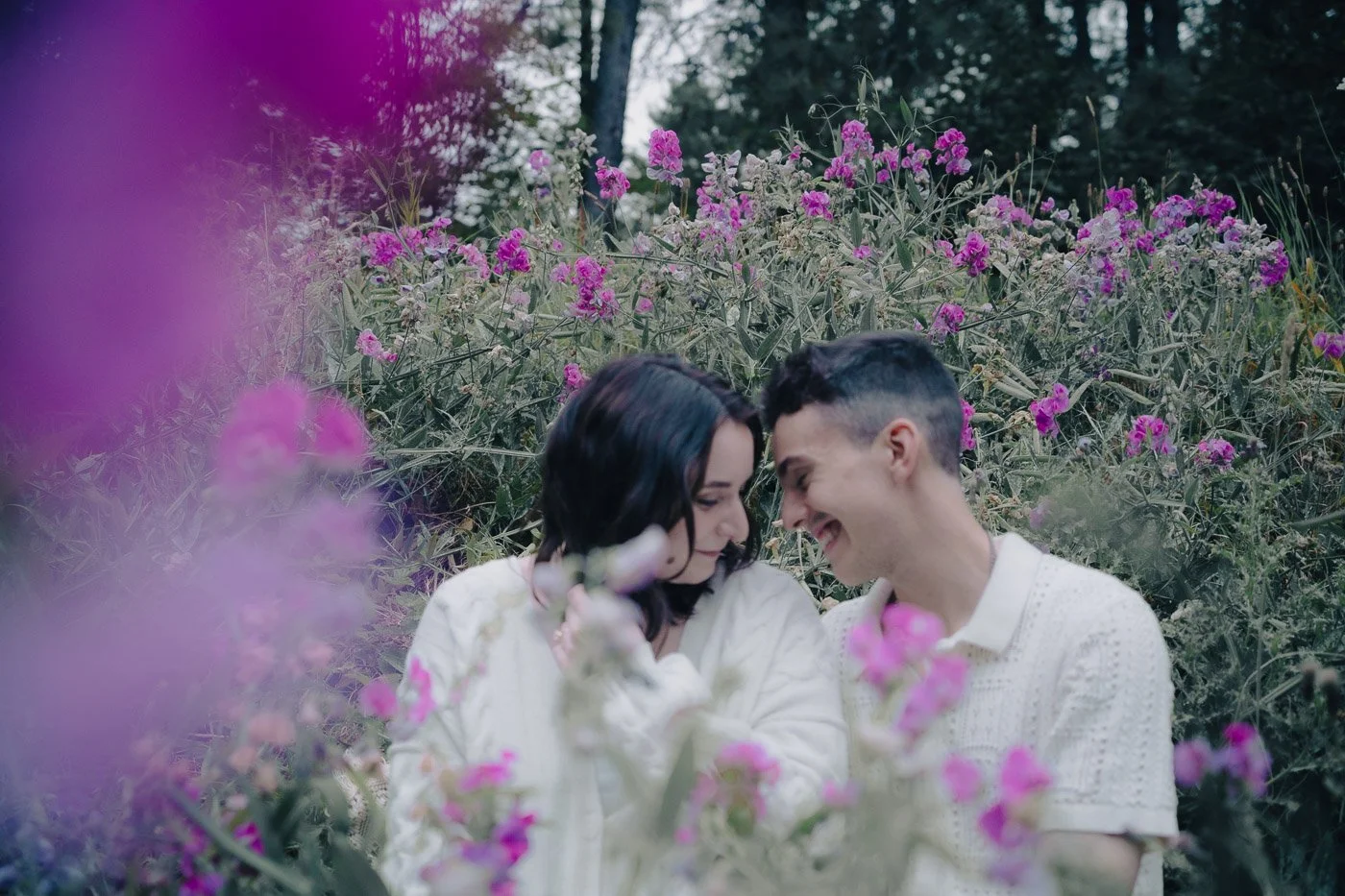 A couple laughing surrounded by purple wild flowers