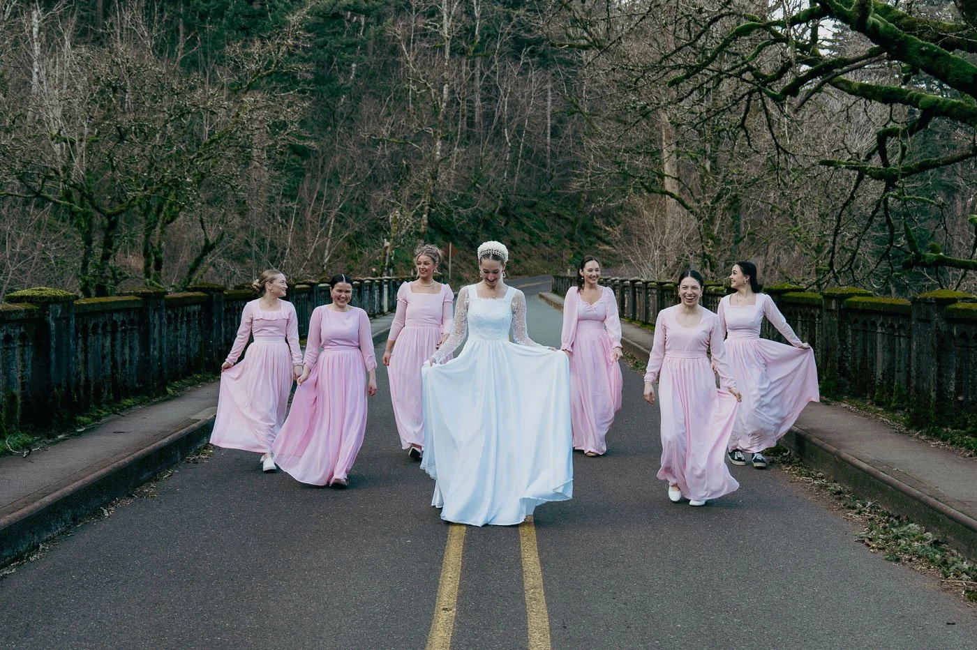 Bridal party in pink and white on a bridge near Latourell Falls