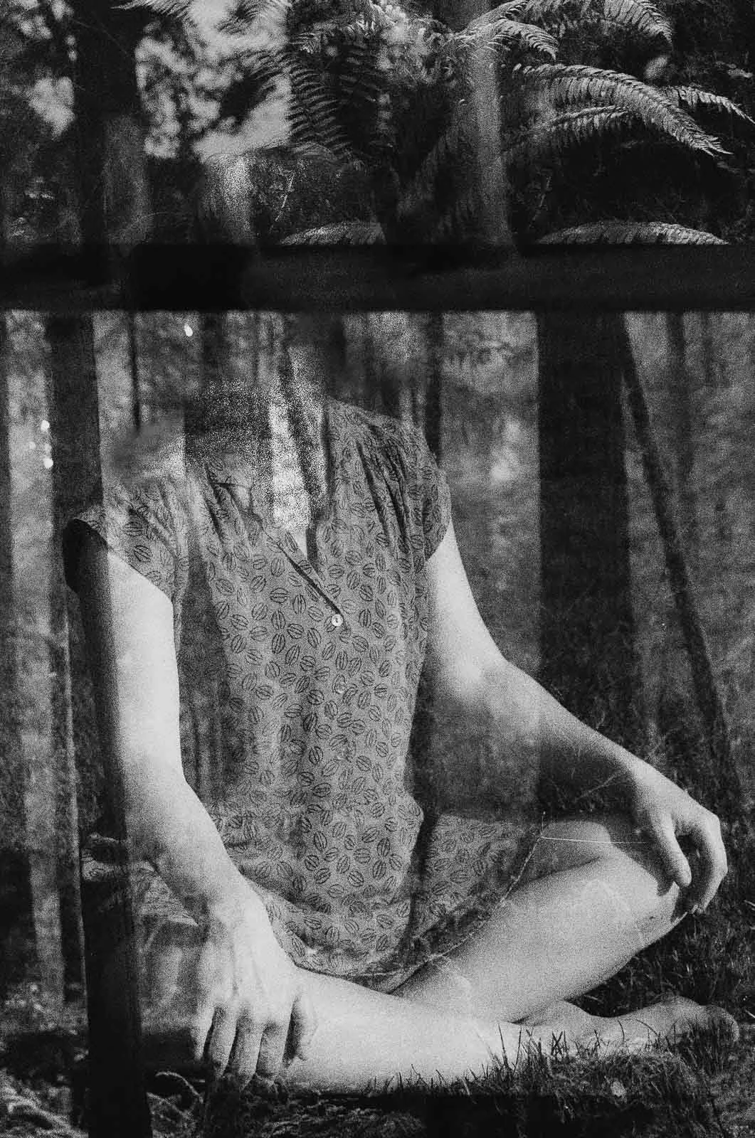 A double exposure of a headless girl sitting in the Redwood forest