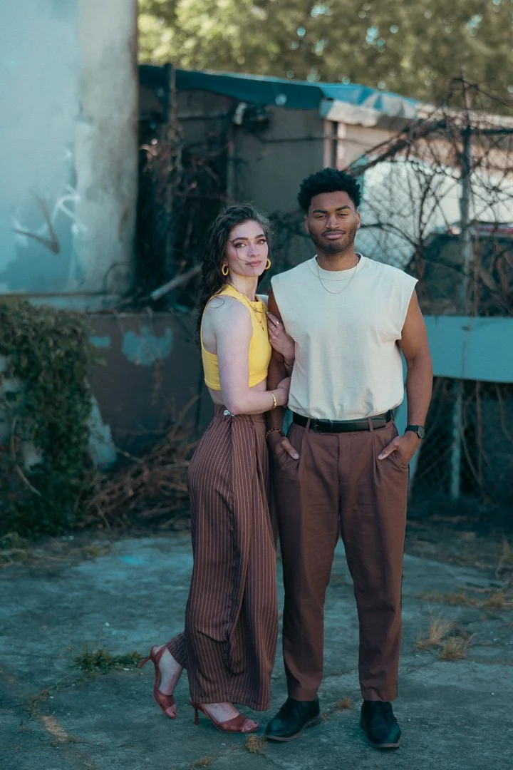 Young stylish couple in matching brown pants pose in an urban environement