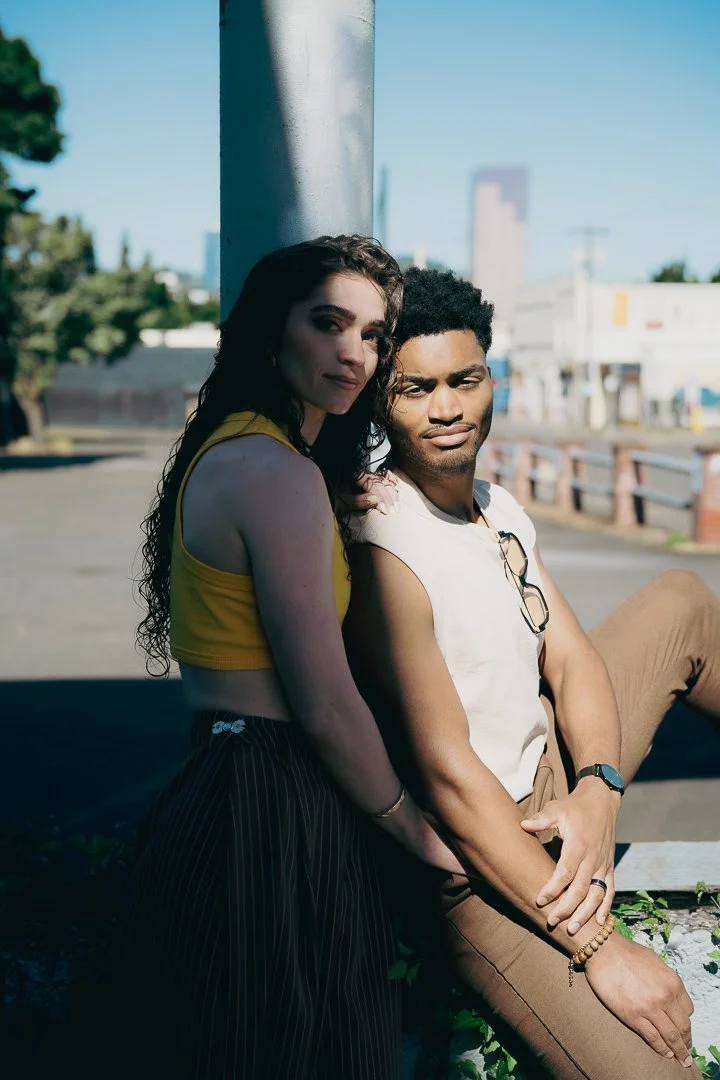Stylish interracial couple leaning against a pole with Big Pink in the background
