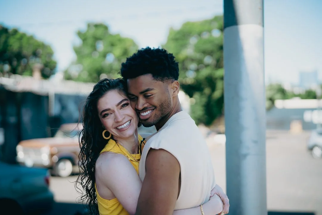 Smiling couple holding each other in an urban environment