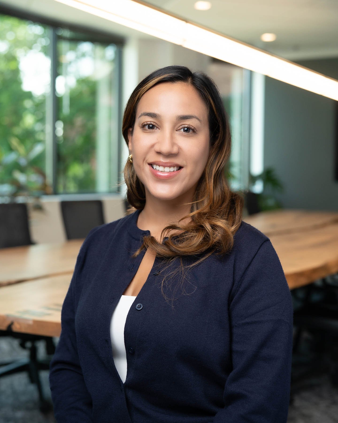  Young hispanic woman smiling in a blue cardigan 