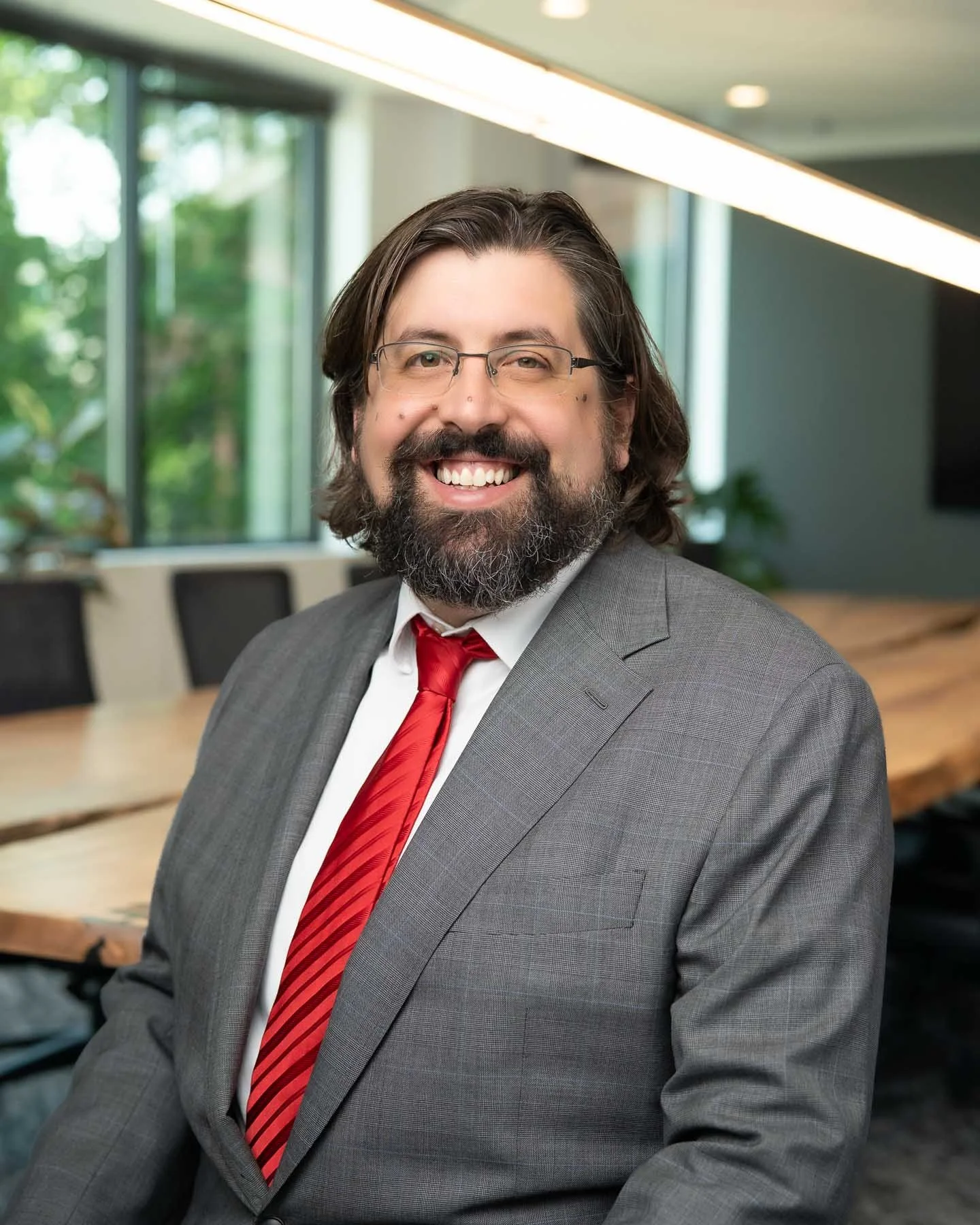  A smiling man in a red tie and suit 