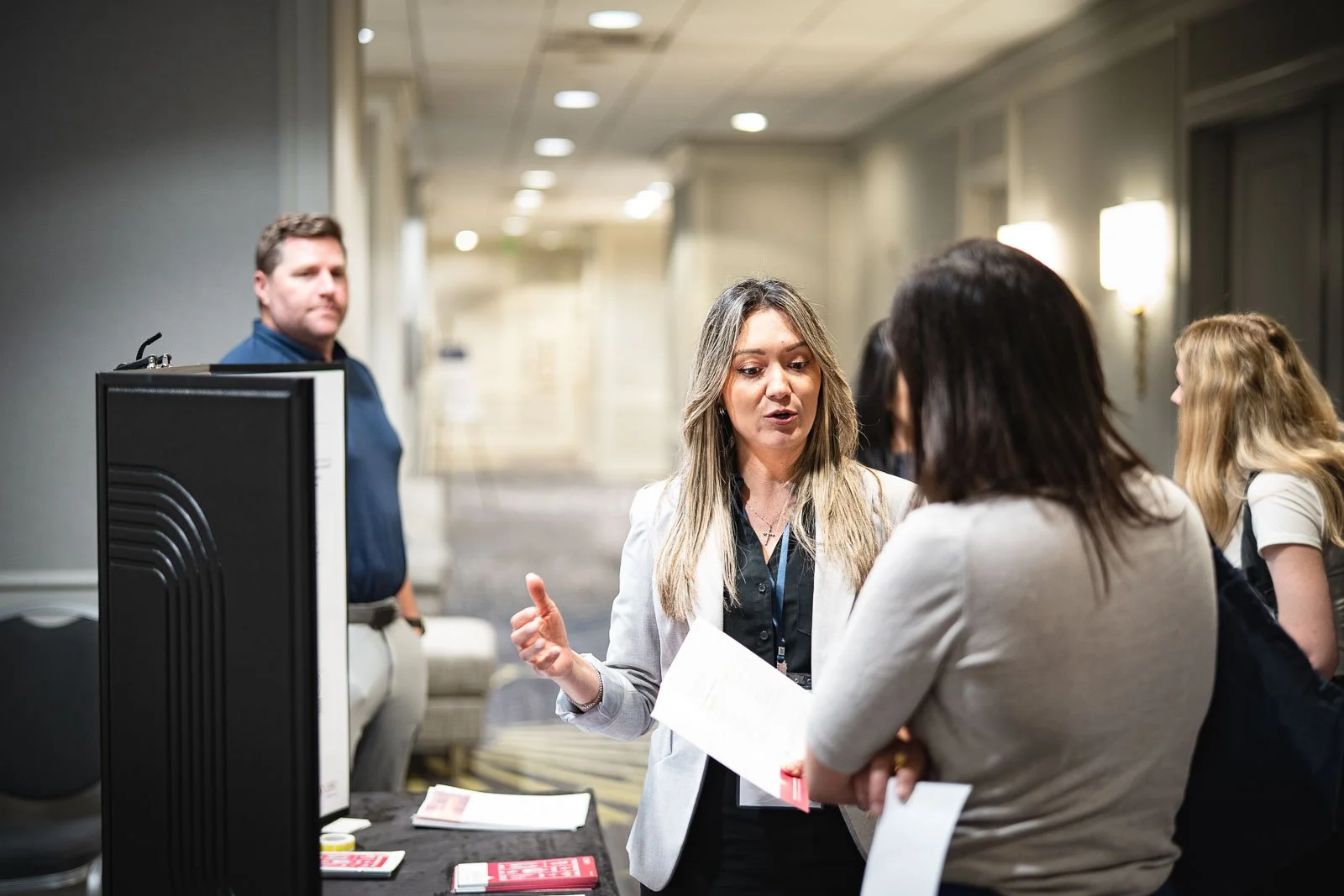 A woman sharing information at a conference booth