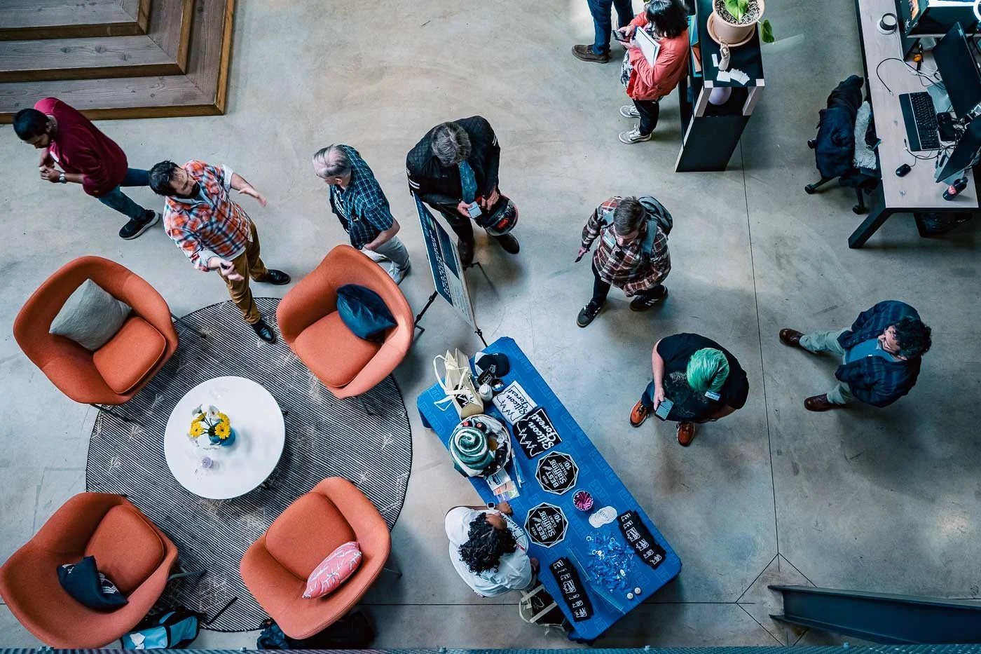 A crowd walking around the info booth at Kiln for a Pro Focus event