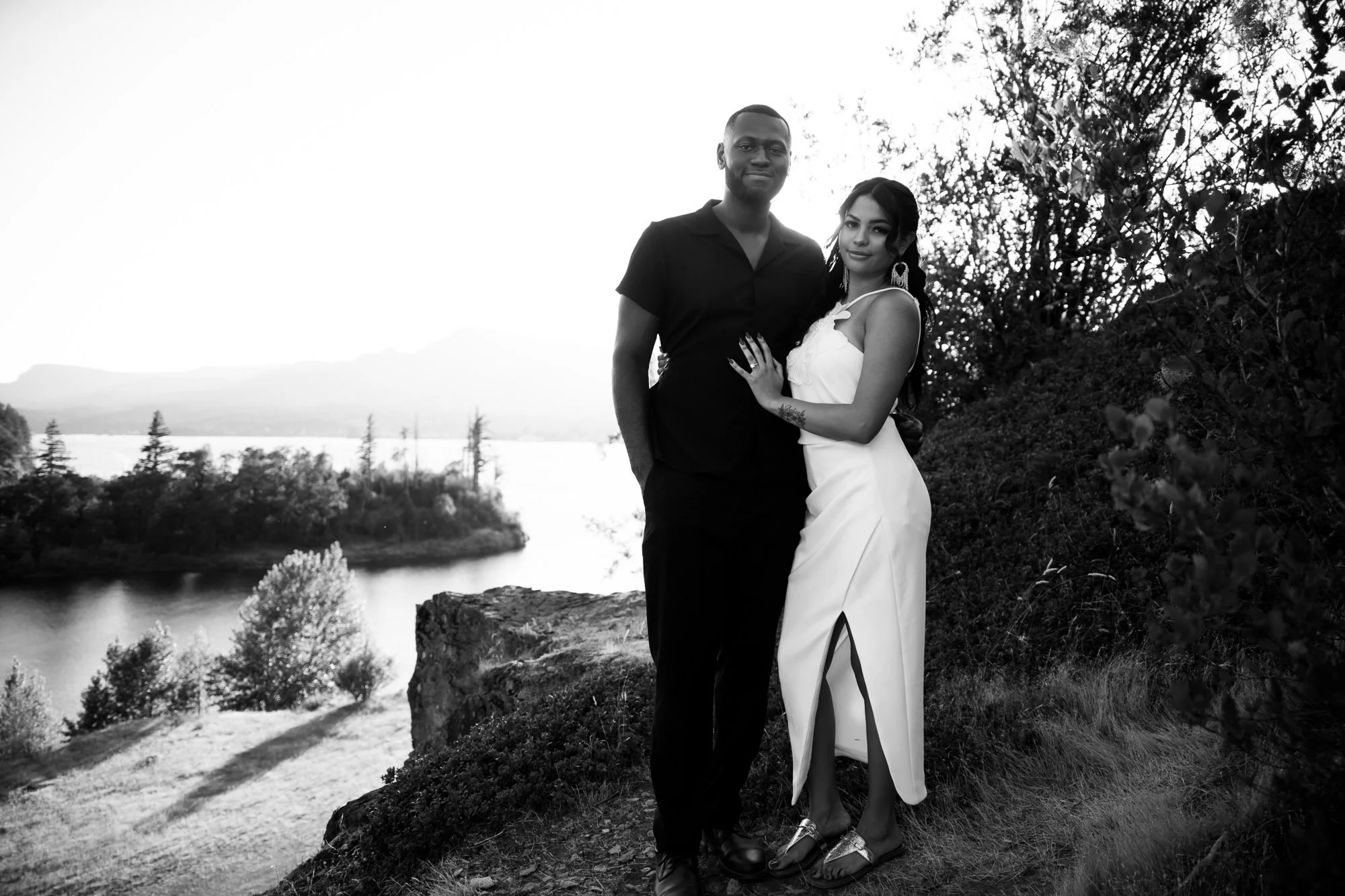 A couple stands on the edge of rocky cliffs above the river at Government Cove