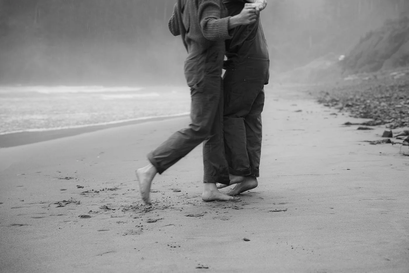 A couple dancing in the rain on the beach