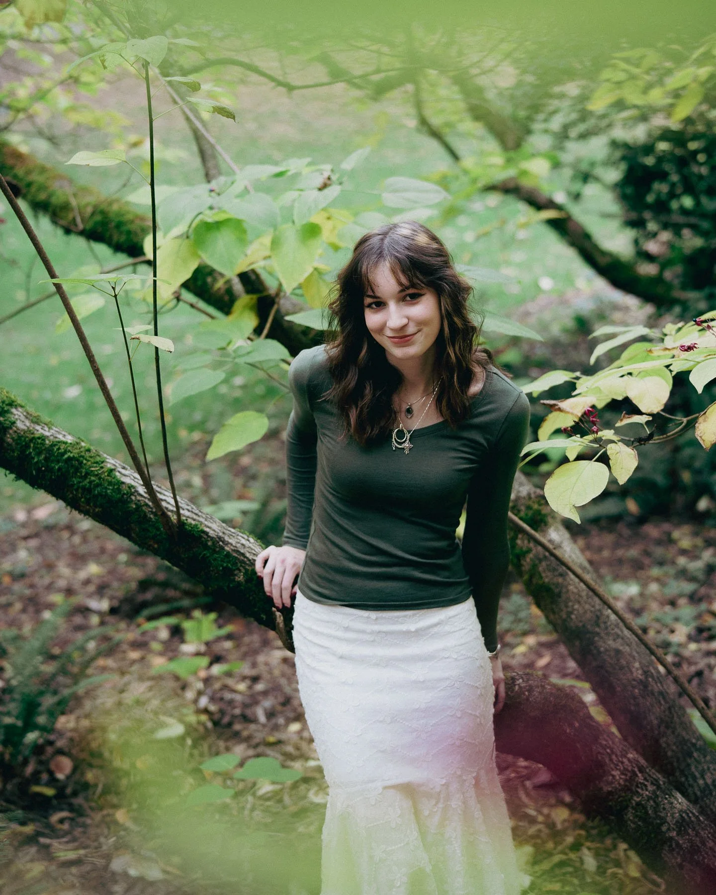Smiling girl leaning against a tree for her portrait