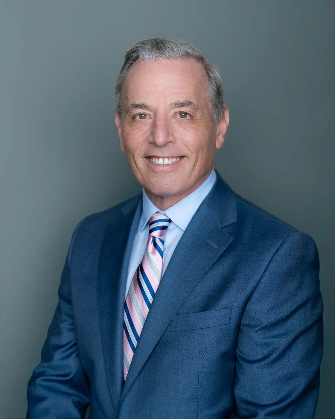 Corporate headshot of CEO in a blue suit