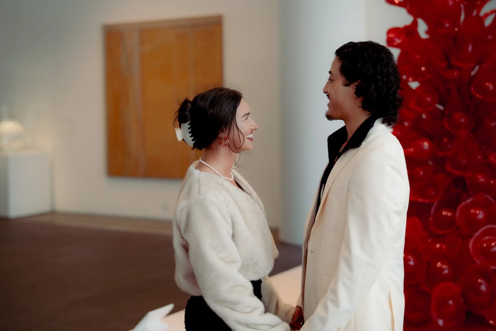 A couple hold hands and laugh next to artwork at the Portland Art Museum