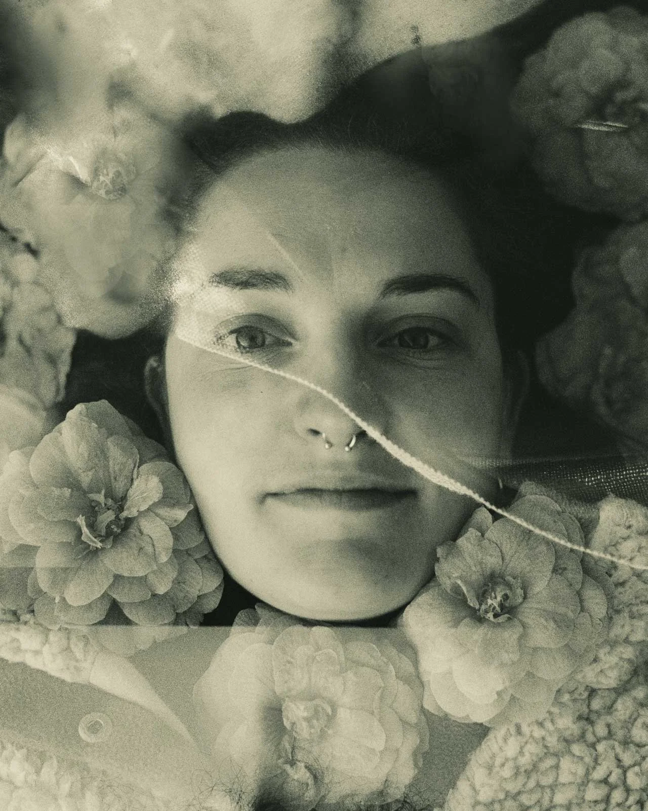 A girls face surrounded by flower petals