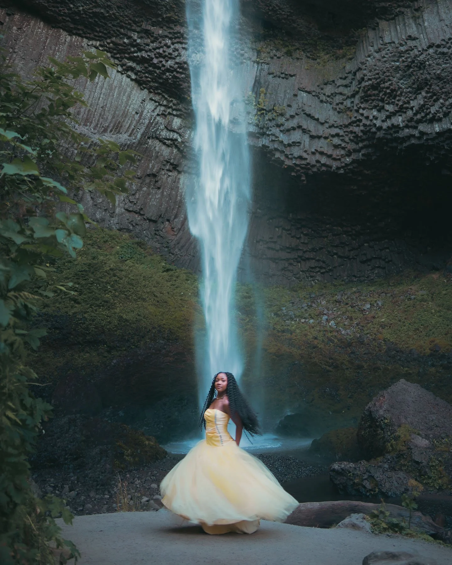 High school student twirling in a yellow dress in front of Latourell Falls