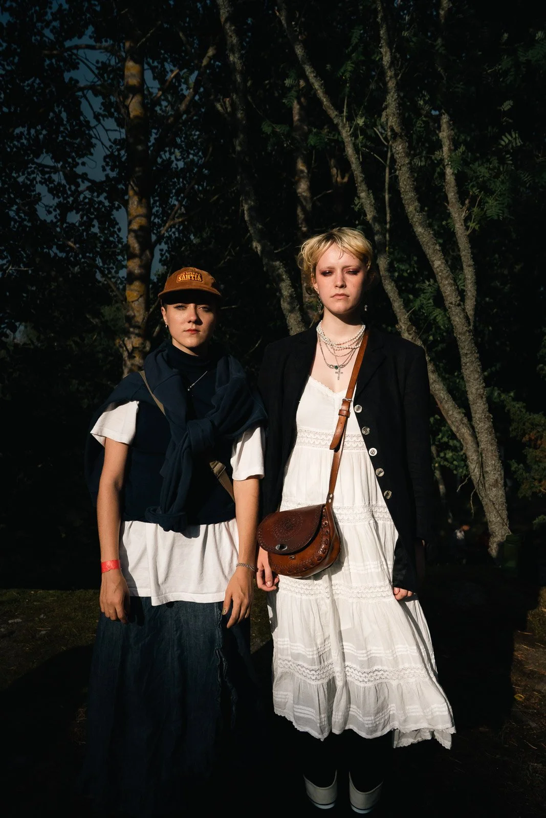 Two girls brightly lit stand side by side with neutral expressions
