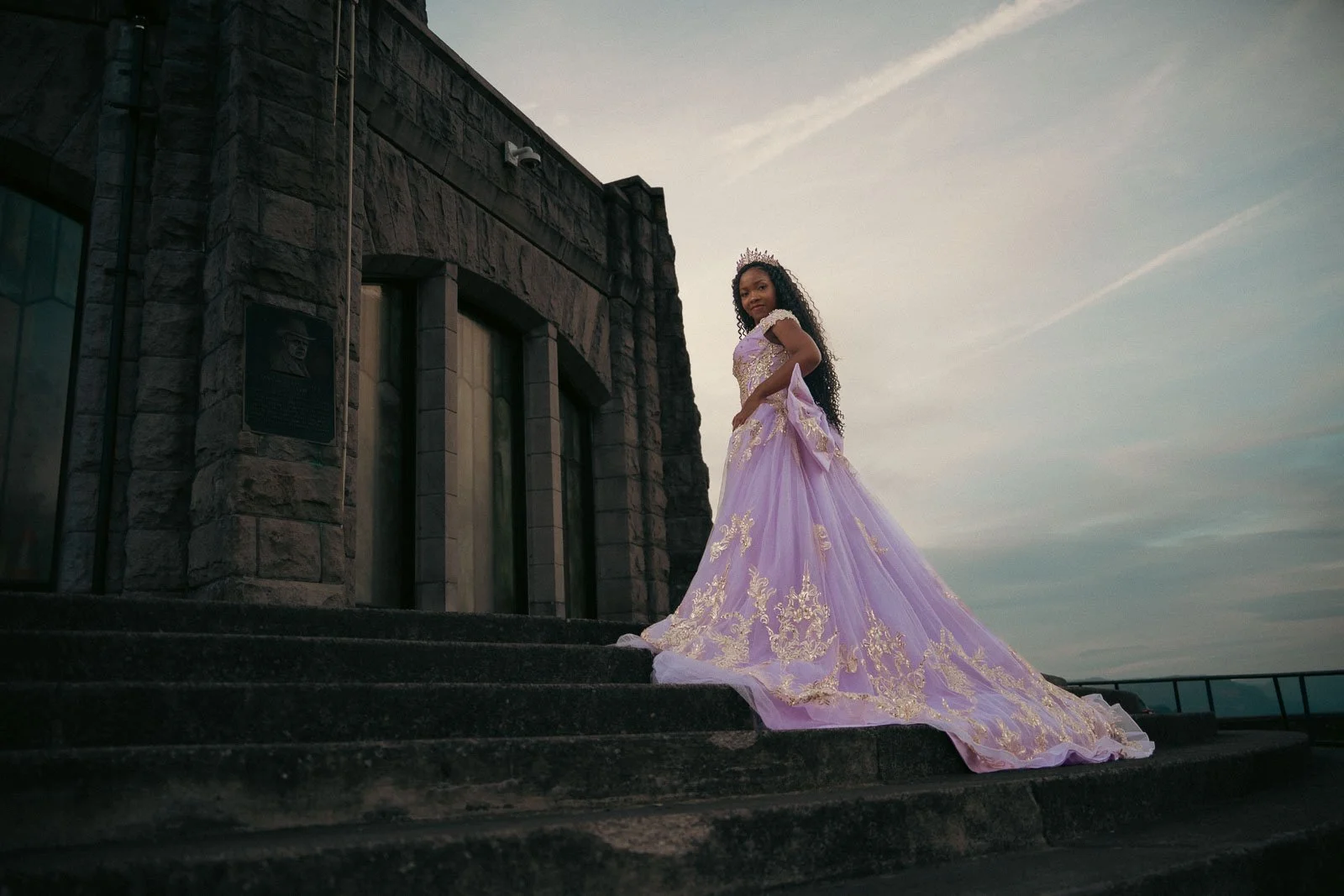 A high school senior climbing the stairs to the Vista House is a long flowing dress