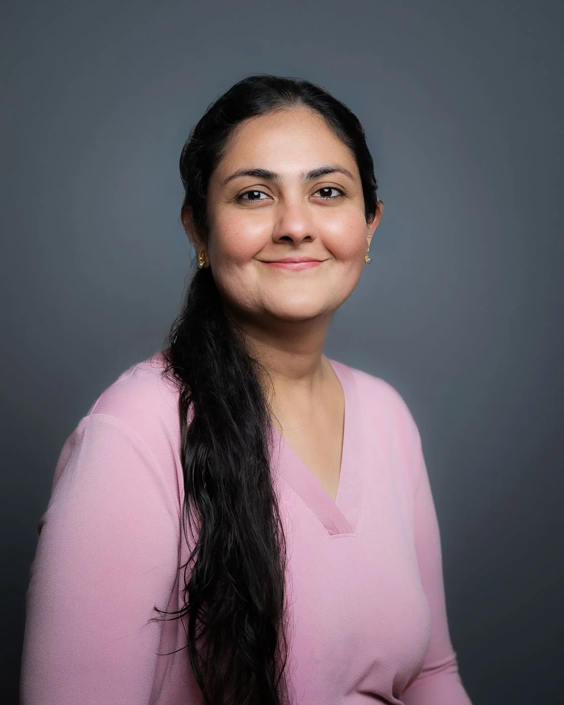 Headshot of a smiling woman in a bright pink shirt