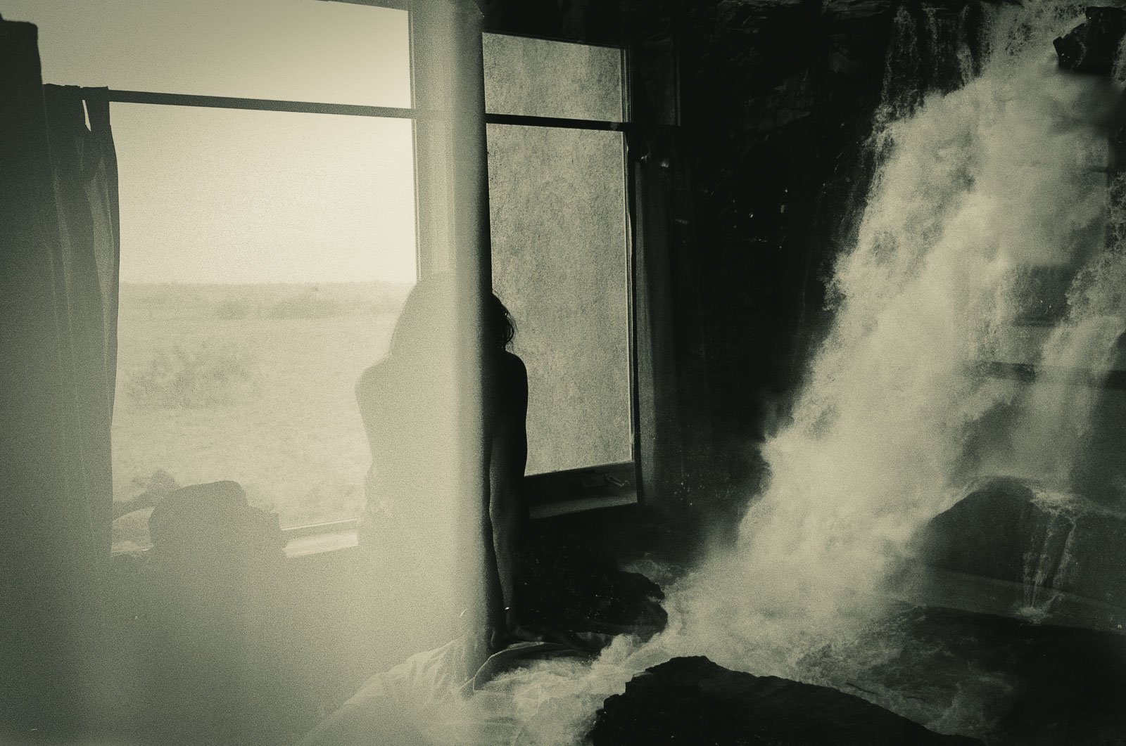 Double exposure of a girl and a waterfall inside a bedroom