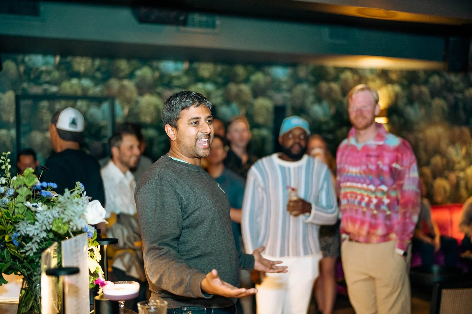 EPPO president giving a speech in a dimly lit bar surrounded by people